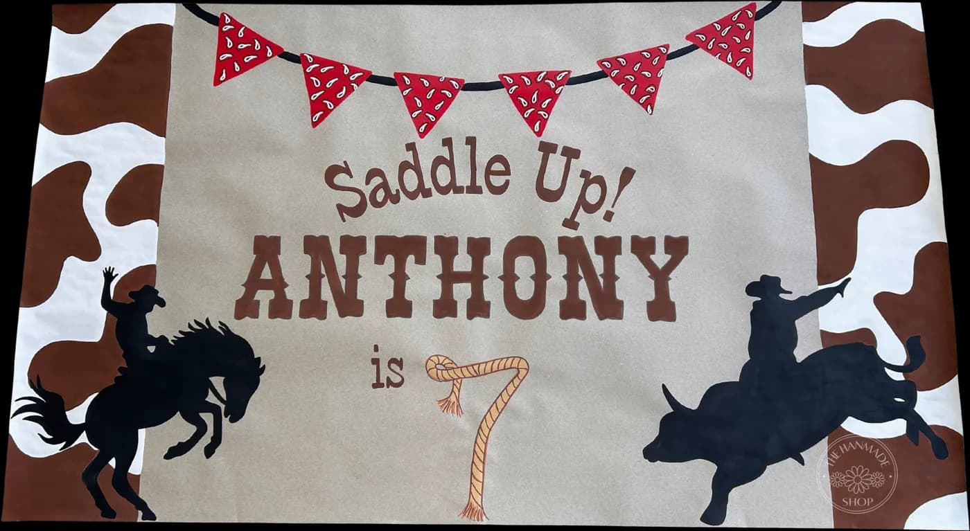 Hand-painted cowboy-themed banner reading Saddle Up, Anthony is 7
